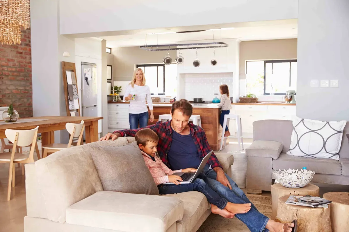 Family relaxing in an open-plan living room and kitchen