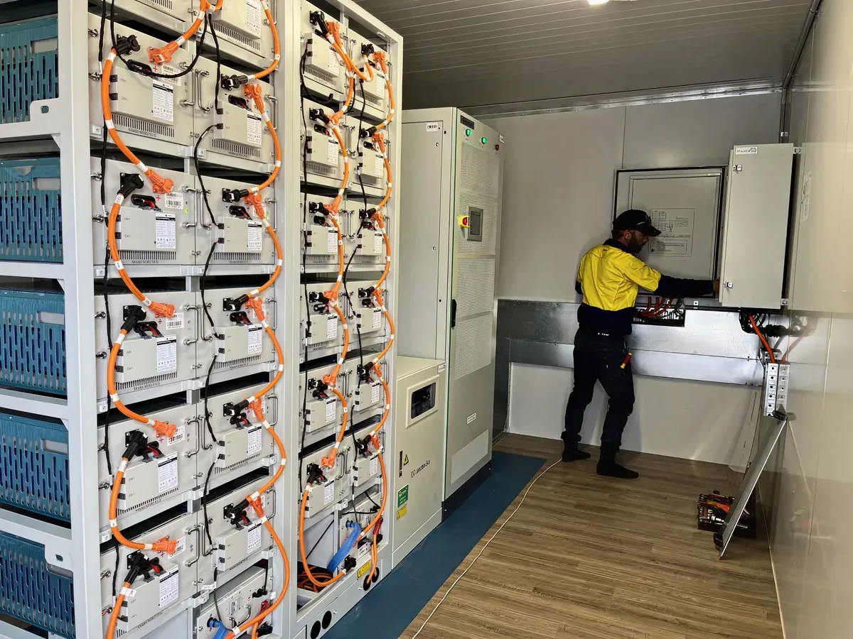 Technician working on an off-grid battery rack installation