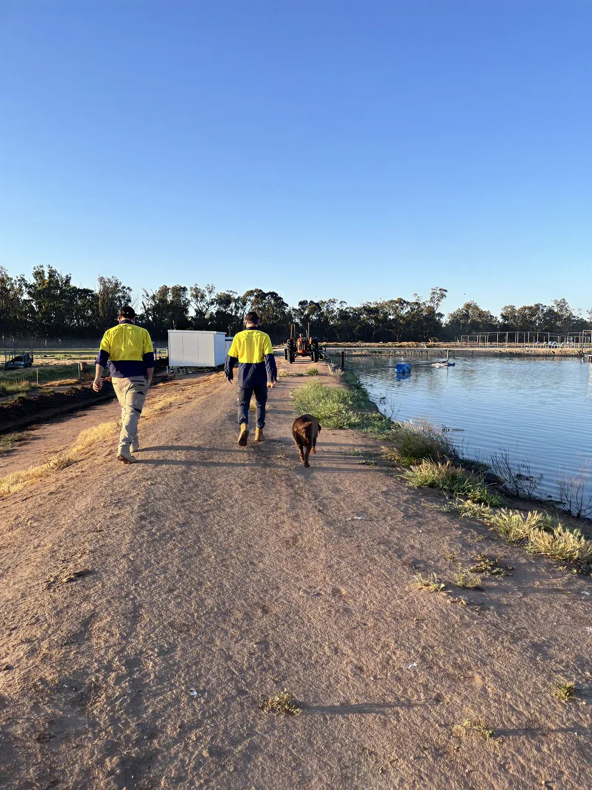 Installers walking beside a water reservoir