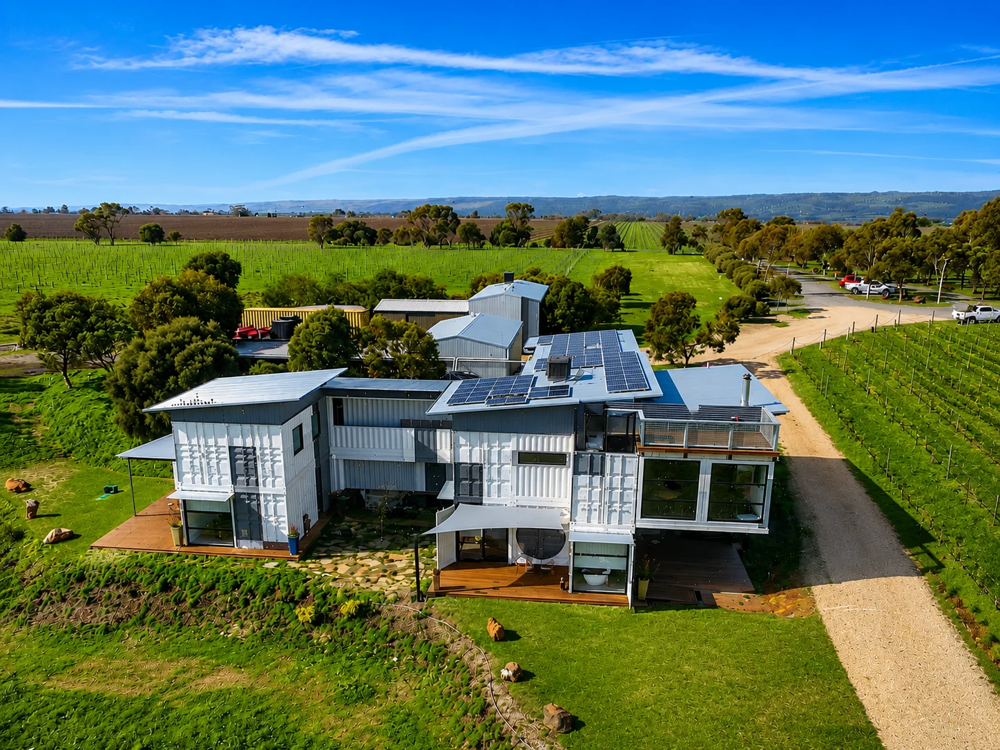 Aerial view of a rural home with its own solar panels and battery system