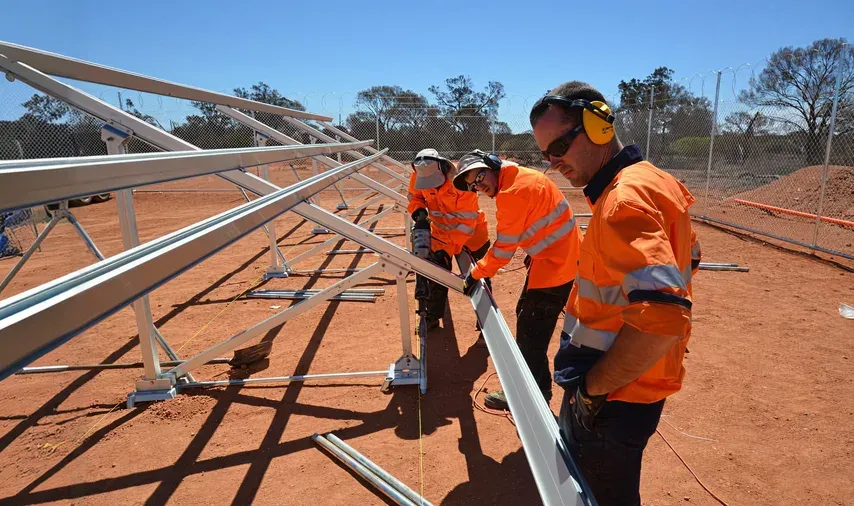 Technicians installing a ground-mounted solar array