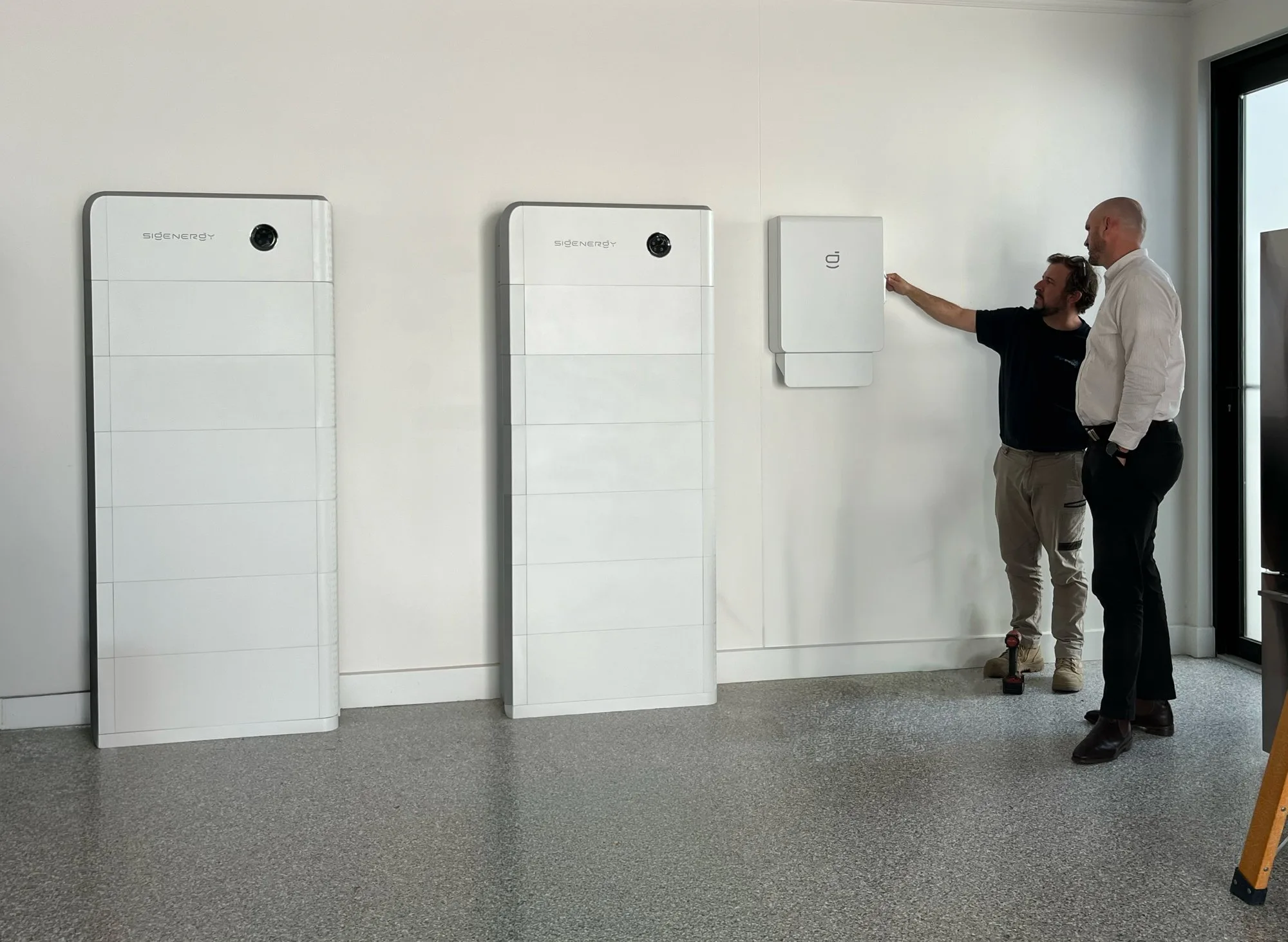 Two Sigenergy battery stacks and a wall-mounted unit in a garage